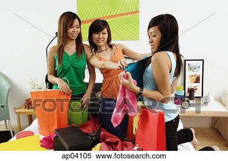 Three girls in bedroom, looking at clothes View Large Photo Image Stock Photography - Three girls in bedroom, looking at clothes . Fotosearch