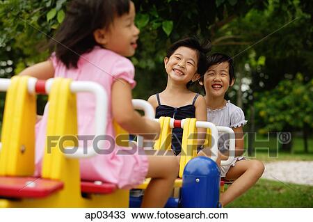 Three girls on a seesaw View Large Photo Image Stock Image - Three girls on a seesaw . Fotosearch