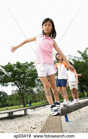Stock Photo - Three girls walking on balance beams. Fotosearch