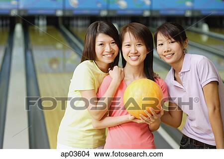 Three women at bowling alley, smiling at camera View Large Photo Image Picture - Three women at bowling alley, smiling at camera . Fotosearch