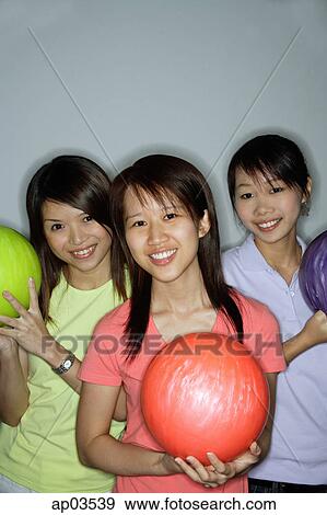 Three young women with bowling balls, smiling View Large Photo Image Stock Photo - Three young women with bowling balls, smiling . Fotosearch