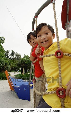 Stock Image - Two boys in playground, looking at camera . Fotosearch