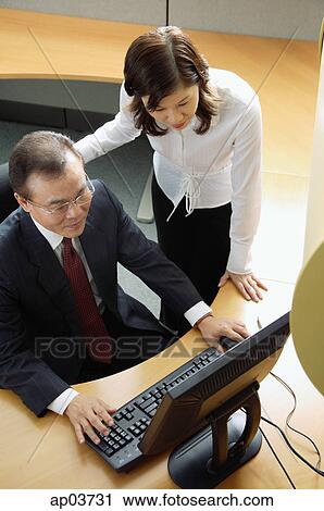 Two business people looking at computer View Large Photo Image Stock Image - Two business people looking at computer . Fotosearch