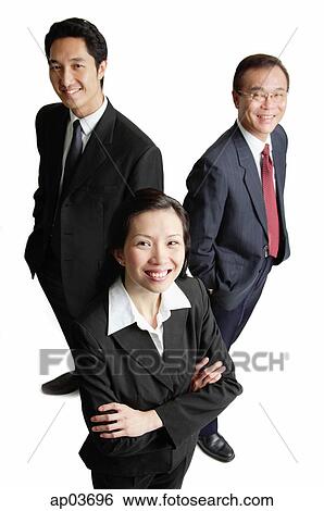 Two businessman and one businesswoman standing, smiling at camera View Large Photo Image Stock Photograph - Two businessman and one businesswoman standing, smiling at camera . Fotosearch