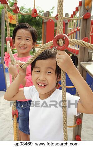 Stock Photo - Two girls in playground, looking at camera. Fotosearch