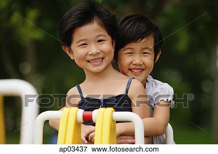 Two girls on a seesaw, smiling, portrait View Large Photo Image Stock Photo - Two girls on a seesaw, smiling, portrait . Fotosearch