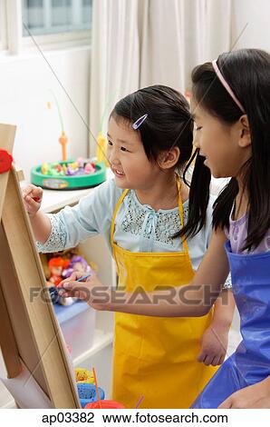 Stock Image - Two girls painting on easel . Fotosearch
