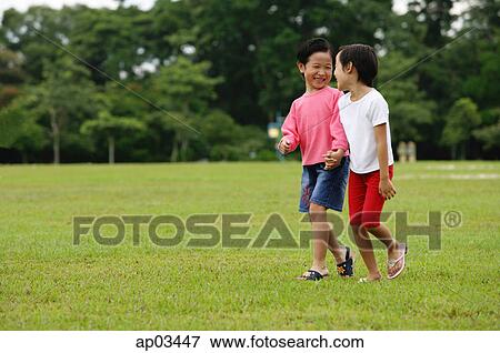 Two girls walking in park, holding hands View Large Photo Image Stock Photo - Two girls walking in park, holding hands. Fotosearch