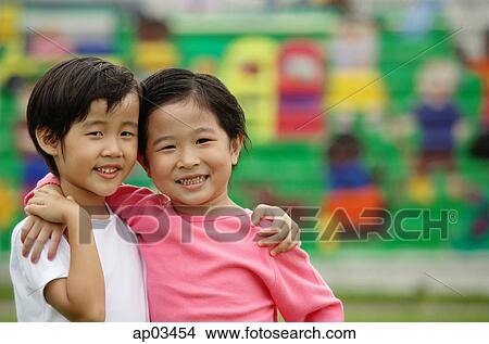 Picture - Two girls with arms around each other, looking at camera. Fotosearch