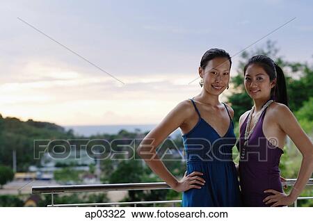 Stock Image - Two women standing together, hands on hips, looking at camera . Fotosearch