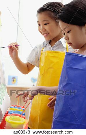 Two young girls painting on easel View Large Photo Image Stock Image - Two young girls painting on easel . Fotosearch