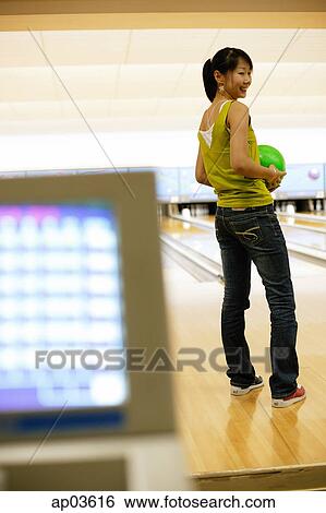 Woman at a bowling alley, holding bowling ball View Large Photo Image Stock Photograph - Woman at a bowling alley, holding bowling ball . Fotosearch