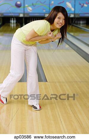 Woman at bowling alley, bending over smiling View Large Photo Image Stock Photograph - Woman at bowling alley, bending over smiling. Fotosearch
