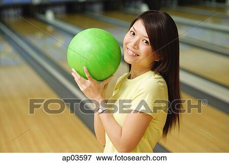 Woman at bowling alley holding green bowling ball View Large Photo Image Stock Photo - Woman at bowling alley holding green bowling ball . Fotosearch