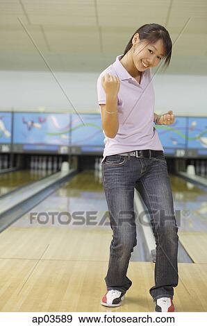 Woman at bowling alley, smiling, making a fist View Large Photo Image Stock Photo - Woman at bowling alley, smiling, making a fist . Fotosearch