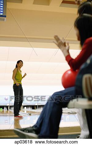 Woman at bowling alley, turning to look at friends behind her View Large Photo Image Stock Photo - Woman at bowling alley, turning to look at friends behind her . Fotosearch