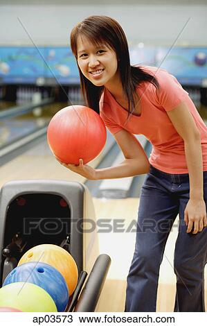 Woman at bowling alley with bowling ball, smiling at camera View Large Photo Image Stock Image - Woman at bowling alley with bowling ball, smiling at camera . Fotosearch