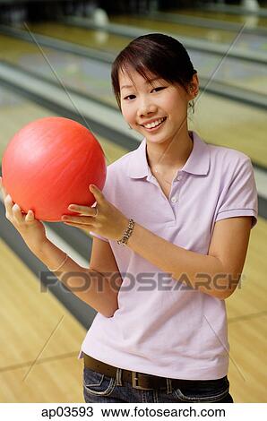 Stock Image - Woman at bowling alley with bowling ball . Fotosearch