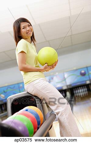 Woman at bowling alley with bowling ball, smiling at camera View Large Photo Image Stock Photography - Woman at bowling alley with bowling ball, smiling at camera. Fotosearch