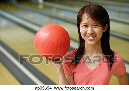 Woman at bowling alley with red bowling ball View Large Photo Image Picture - Woman at bowling alley with red bowling ball . Fotosearch