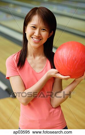 Stock Photography - Woman at bowling alley with red bowling ball . Fotosearch
