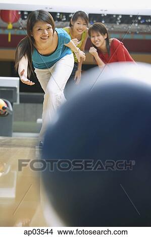Woman bowling, friends behind her watching View Large Photo Image Picture - Woman bowling, friends behind her watching . Fotosearch