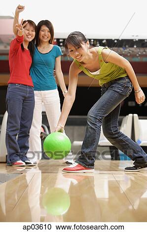 Woman bowling, friends watching her in the background View Large Photo Image Stock Image - Woman bowling, friends watching her in the background . Fotosearch