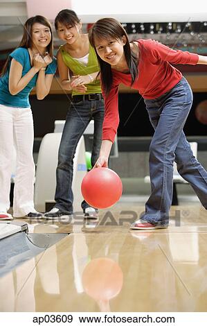 Stock Photo - Woman bowling, friends watching her . Fotosearch