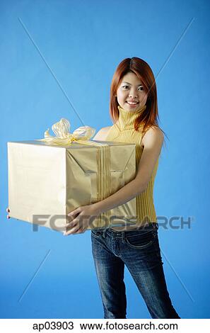 Woman carrying big gift box, smiling View Large Photo Image Stock Image - Woman carrying big gift box, smiling . Fotosearch