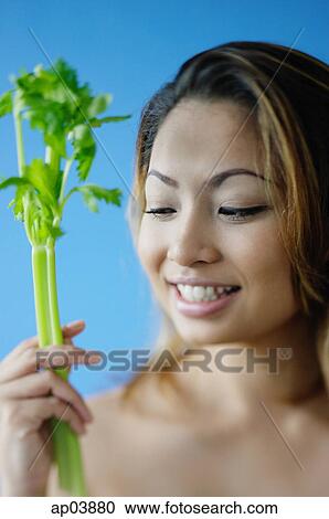Woman holding a stick of celery View Large Photo Image Stock Image - Woman holding a stick of celery . Fotosearch