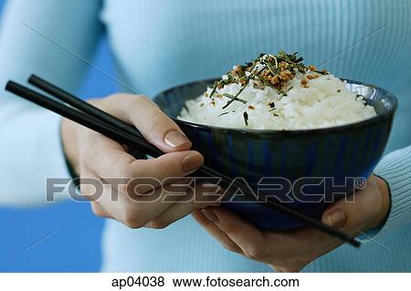 Woman holding bowl of rice and chopsticks View Large Photo Image Stock Photo - Woman holding bowl of rice and chopsticks. Fotosearch