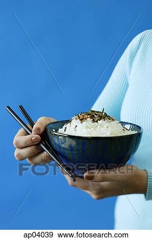 Stock Photo - Woman holding bowl of rice and chopsticks . Fotosearch