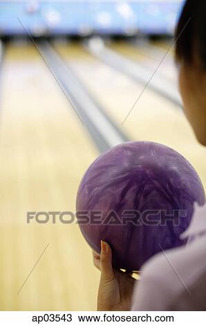 Woman holding bowling ball, over the shoulder view View Large Photo Image Stock Image - Woman holding bowling ball, over the shoulder view . Fotosearch