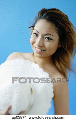 Picture - Woman holding hat over chest . Fotosearch