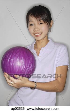 Woman holding purple bowling ball, smiling at camera View Large Photo Image Stock Photograph - Woman holding purple bowling ball, smiling at camera . Fotosearch
