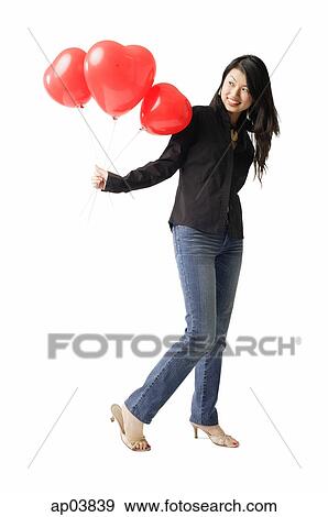 Stock Photo - Woman holding red balloons, smiling . Fotosearch