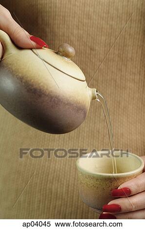 Woman holding teapot, pouring tea View Large Photo Image Stock Photography - Woman holding teapot, pouring tea. Fotosearch