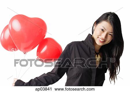 Woman holding three red balloons, portrait View Large Photo Image Stock Image - Woman holding three red balloons, portrait. Fotosearch