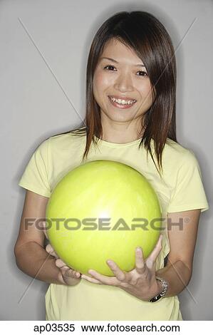 Woman holding yellow bowling ball, smiling at camera View Large Photo Image Stock Photography - Woman holding yellow bowling ball, smiling at camera . Fotosearch