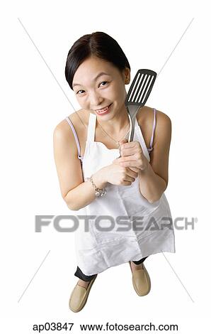 Stock Photo - Woman in apron holding kitchen utensil . Fotosearch