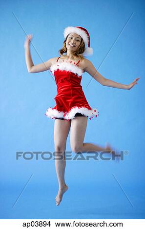 Woman in Santa hat and red dress, jumping View Large Photo Image Picture - Woman in Santa hat and red dress, jumping. Fotosearch