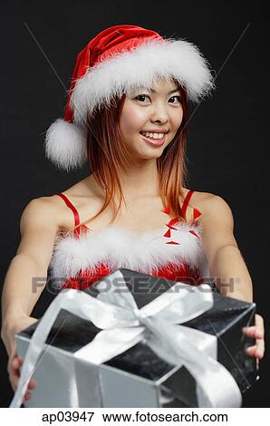 Woman in Santa hat and red dress, holding silver gift box View Large Photo Image Stock Photo - Woman in Santa hat and red dress, holding silver gift box . Fotosearch