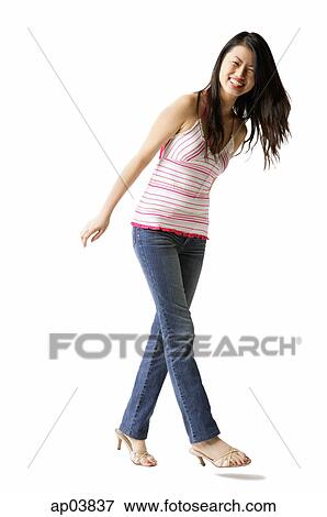 Stock Photo - Woman in striped top and jeans, smiling at camera . Fotosearch