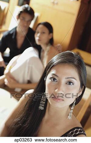 Woman looking at camera, couple in the background View Large Photo Image Stock Image - Woman looking at camera, couple in the background . Fotosearch