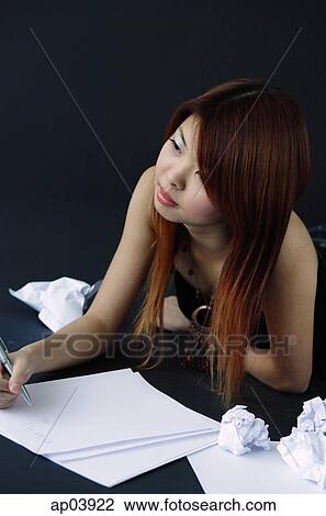 Woman lying down with pen and paper, looking away View Large Photo Image Stock Image - Woman lying down with pen and paper, looking away. Fotosearch
