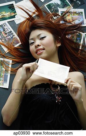 Woman lying on floor, holding postcard View Large Photo Image Stock Image - Woman lying on floor, holding postcard . Fotosearch