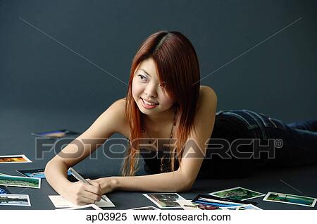 Woman lying on floor, writing on backs of photographs View Large Photo Image Stock Photography - Woman lying on floor, writing on backs of photographs. Fotosearch