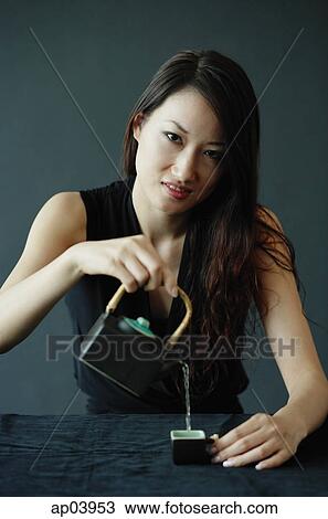 Woman pouring tea, looking at camera View Large Photo Image Stock Image - Woman pouring tea, looking at camera . Fotosearch