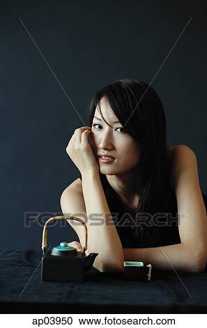Woman sitting, looking at camera, teacup and teapot next to her View Large Photo Image Stock Image - Woman sitting, looking at camera, teacup and teapot next to her. Fotosearch
