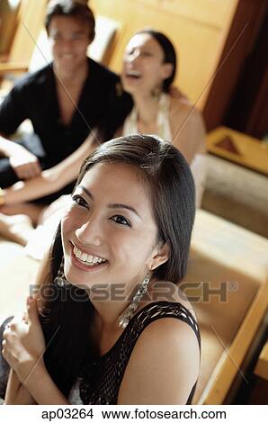 Picture - Woman smiling, couple in the background . Fotosearch